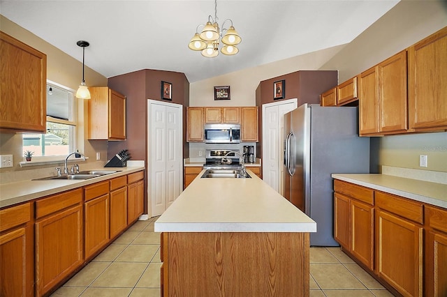 kitchen with pendant lighting, stainless steel appliances, sink, and a kitchen island with sink