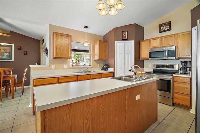 kitchen featuring appliances with stainless steel finishes, sink, pendant lighting, and lofted ceiling