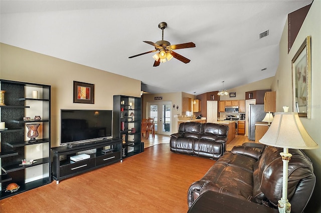 living room featuring ceiling fan, lofted ceiling, and light hardwood / wood-style floors