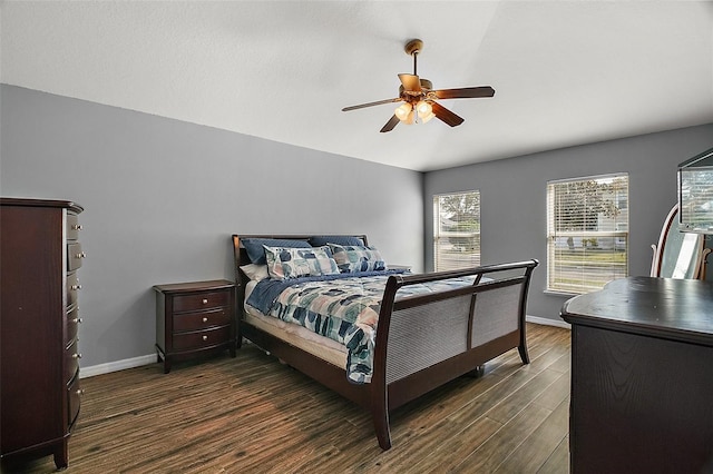 bedroom with ceiling fan, vaulted ceiling, and dark hardwood / wood-style flooring