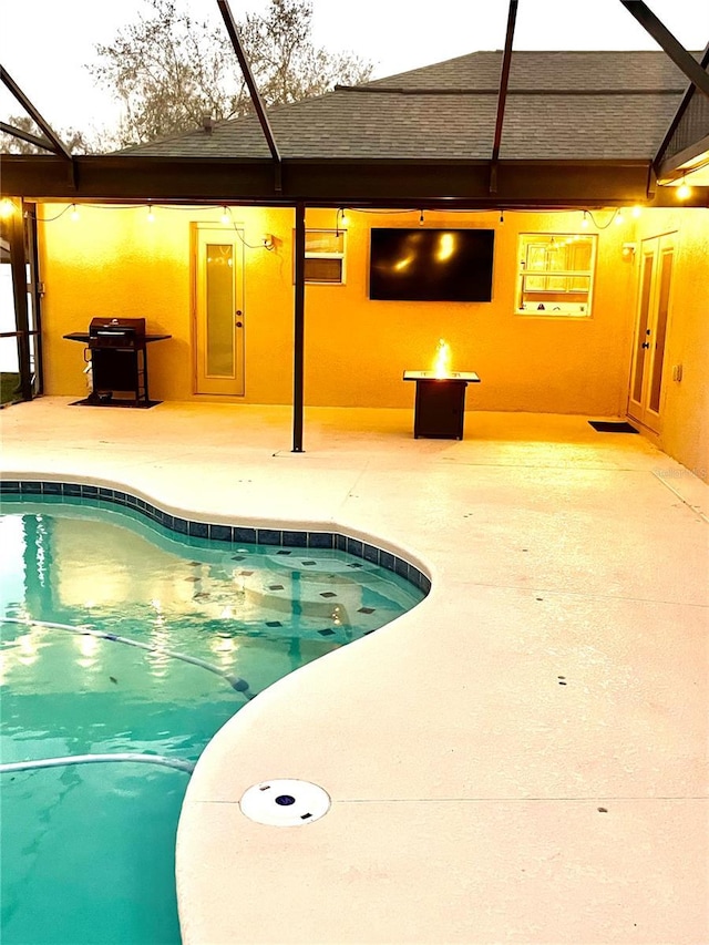 view of pool featuring an outdoor fire pit, glass enclosure, and a patio area