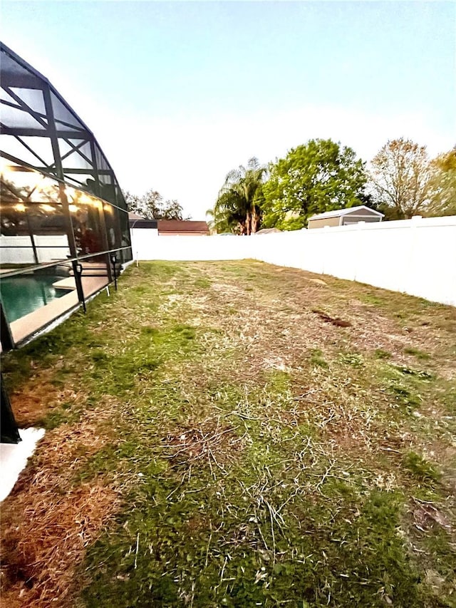 view of yard with a lanai and a fenced in pool