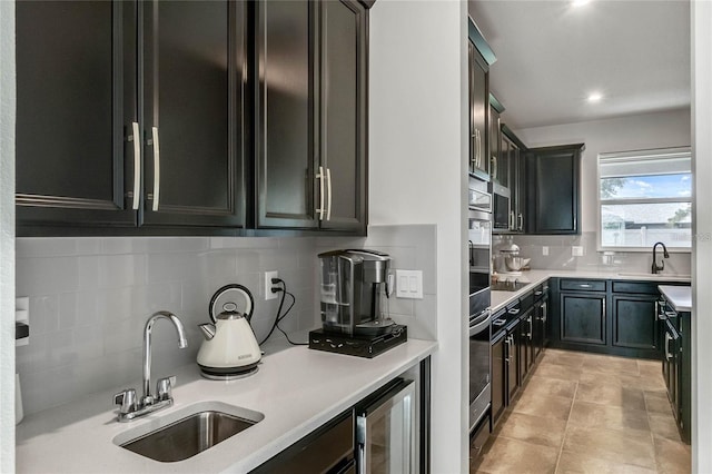 kitchen featuring wine cooler, stainless steel oven, sink, and decorative backsplash