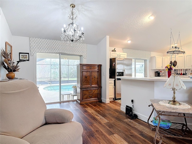 living room with dark wood-type flooring and a notable chandelier