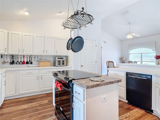 kitchen with white cabinets, lofted ceiling, a center island, and black appliances