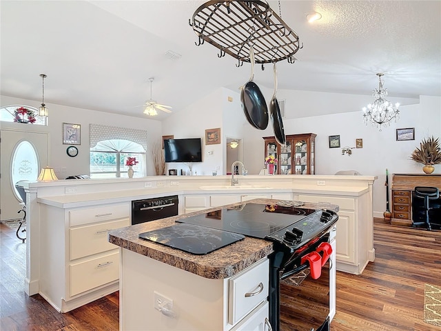 kitchen featuring a kitchen island, sink, pendant lighting, and black appliances