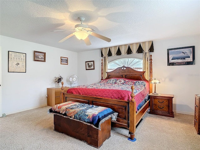 bedroom featuring light carpet, ceiling fan, and a textured ceiling