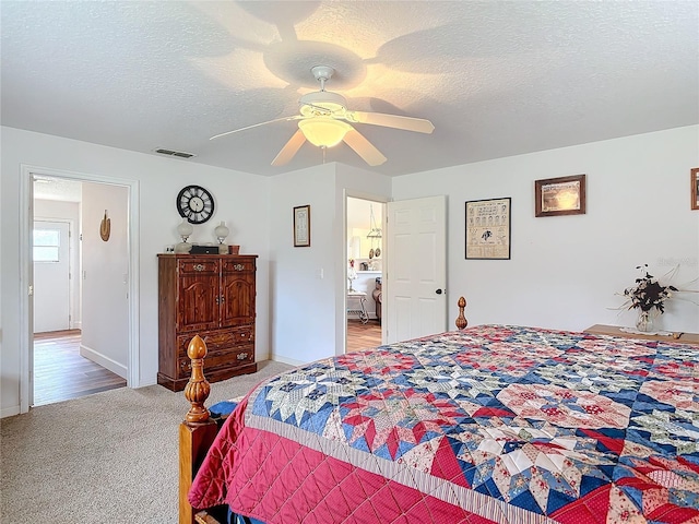 bedroom with ceiling fan, carpet, and a textured ceiling