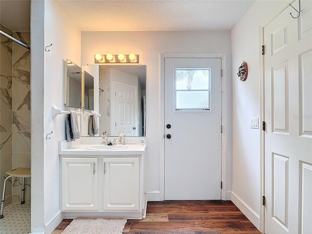 bathroom with wood-type flooring, a textured ceiling, and vanity