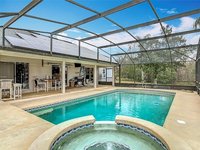 view of pool with a bar, a lanai, a patio area, and an in ground hot tub