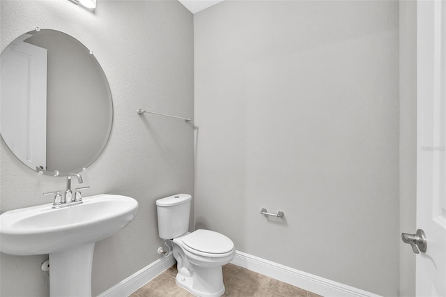 bathroom with tile patterned flooring, sink, and toilet