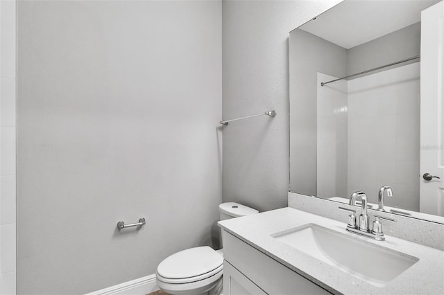 bathroom featuring vanity, toilet, and walk in shower