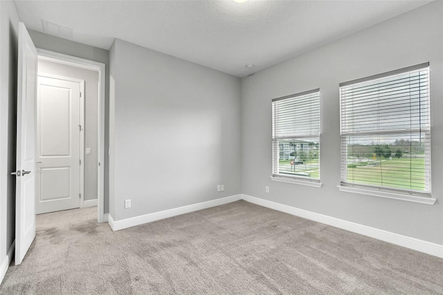 carpeted empty room featuring a textured ceiling