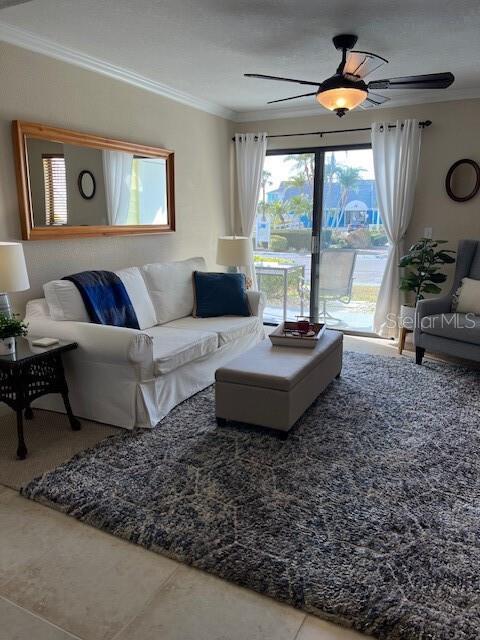 living room with crown molding, tile patterned floors, and ceiling fan