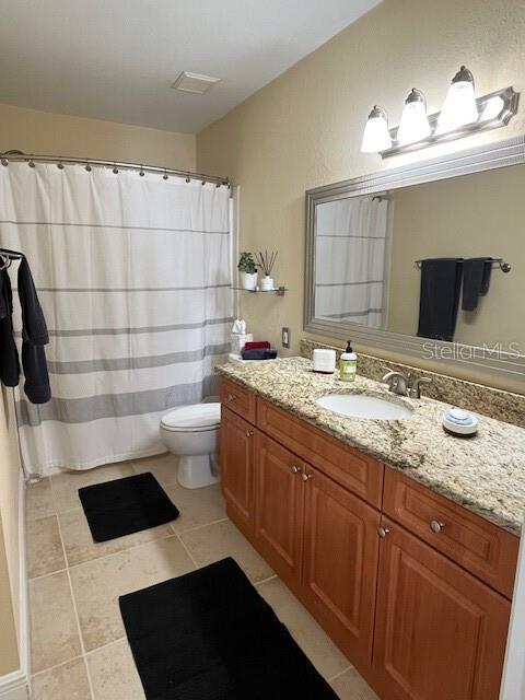 bathroom with vanity, tile patterned floors, and toilet