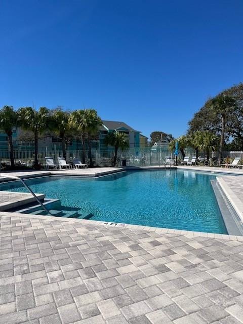 pool with a patio area and fence