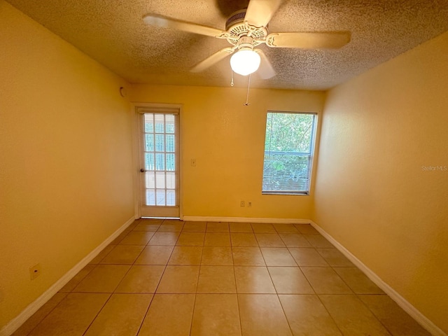 tiled spare room with a textured ceiling and ceiling fan