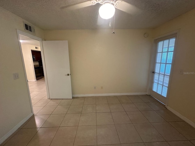 tiled spare room with ceiling fan and a textured ceiling