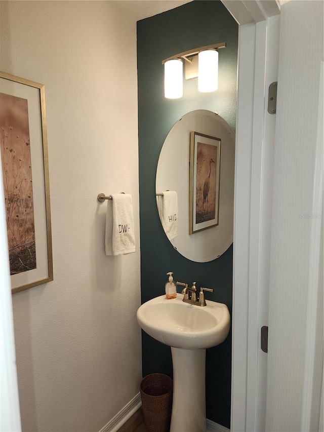 bathroom with a sink and baseboards