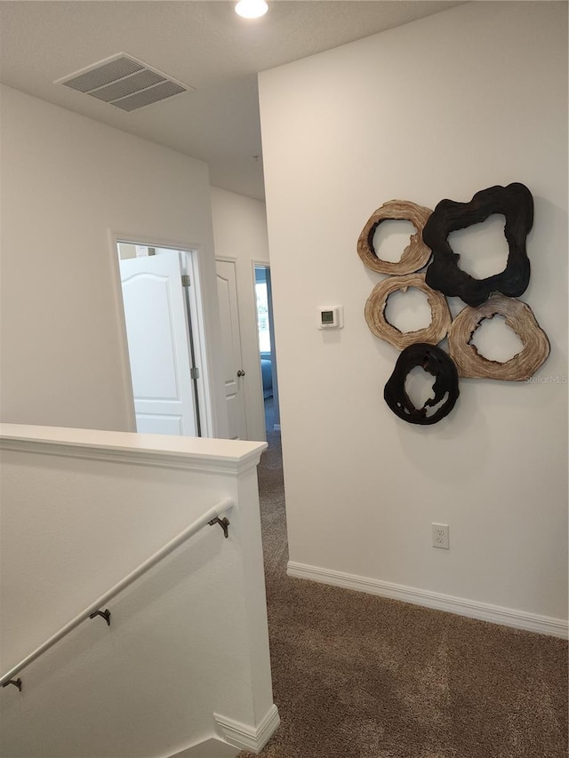 hall featuring baseboards, visible vents, an upstairs landing, dark carpet, and recessed lighting