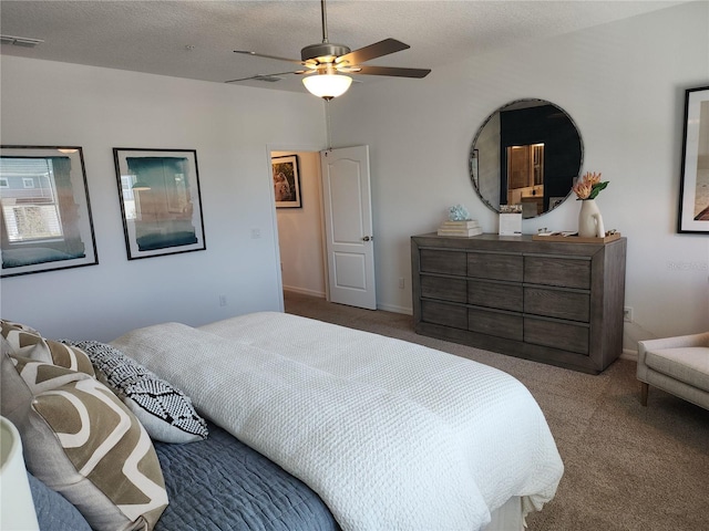 carpeted bedroom featuring a textured ceiling, ceiling fan, visible vents, and baseboards