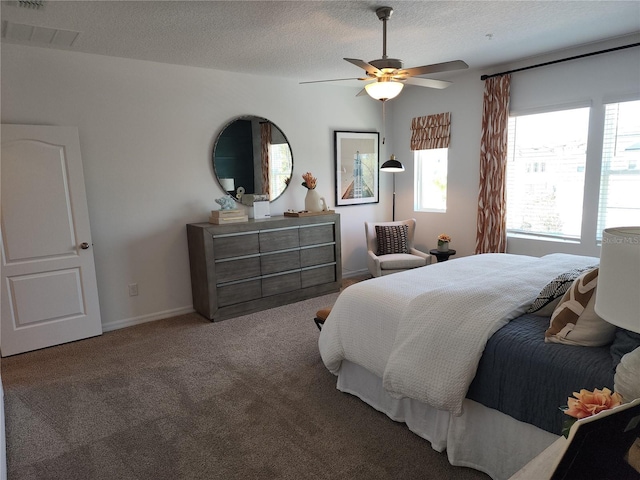 bedroom featuring a textured ceiling, visible vents, baseboards, a ceiling fan, and carpet