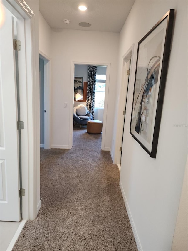 corridor with carpet flooring and baseboards