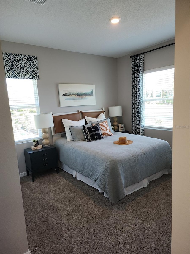 carpeted bedroom with visible vents and a textured ceiling