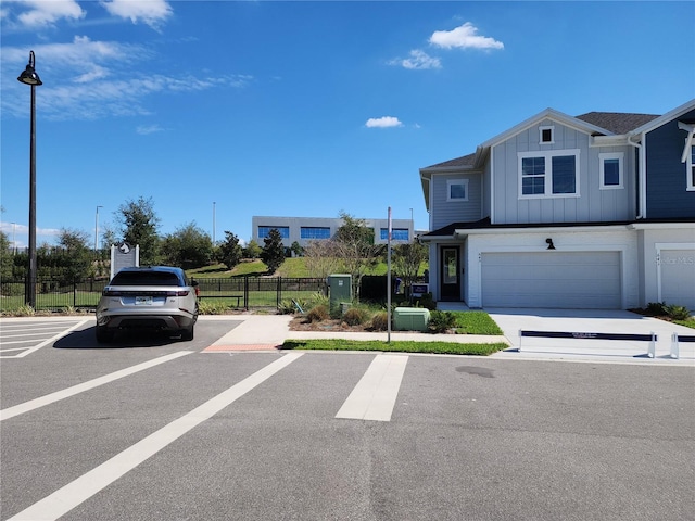 view of front of home with central AC unit, fence, and board and batten siding