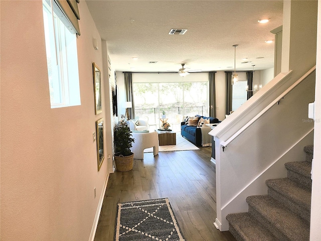 foyer featuring baseboards, visible vents, stairway, and wood finished floors