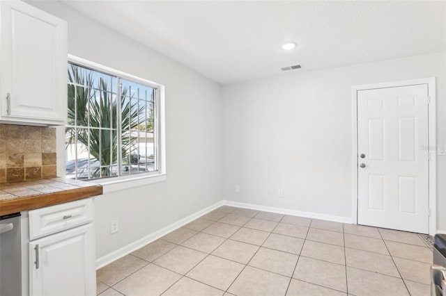 unfurnished dining area with light tile patterned flooring