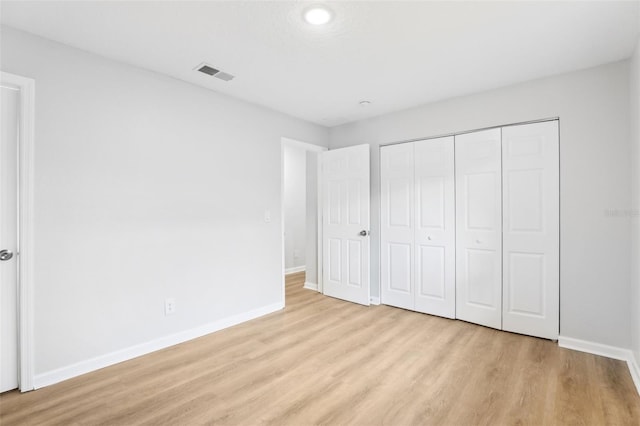 unfurnished bedroom with a closet and light wood-type flooring