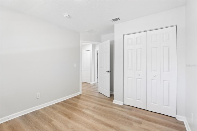 unfurnished bedroom with light hardwood / wood-style floors and a closet