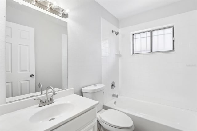 full bathroom with tiled shower / bath, vanity, and toilet