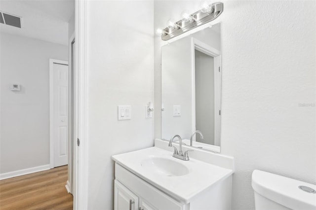 bathroom featuring hardwood / wood-style flooring, vanity, and toilet