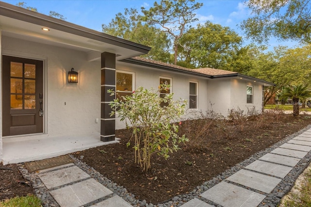 exterior space featuring roof with shingles and stucco siding