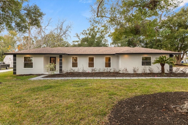 ranch-style home featuring a front yard and stucco siding