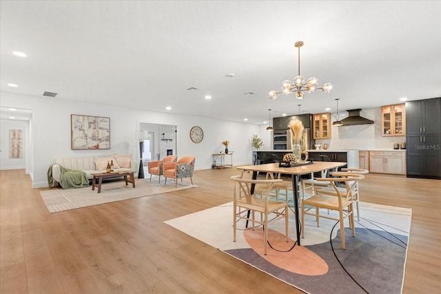 dining space featuring baseboards, visible vents, light wood-type flooring, a chandelier, and recessed lighting