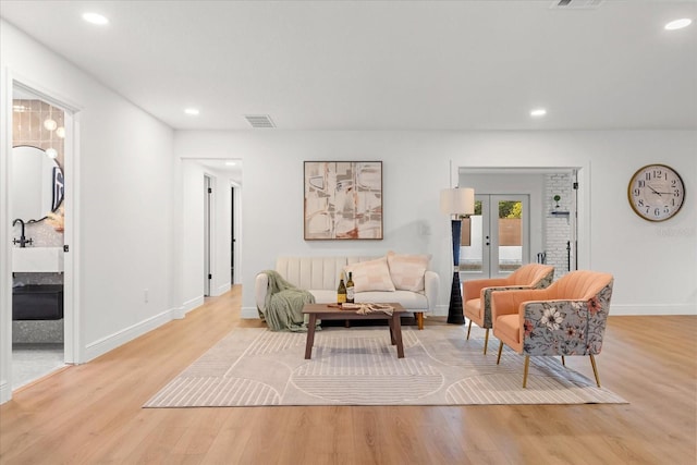 living area with light wood-style floors, recessed lighting, and visible vents