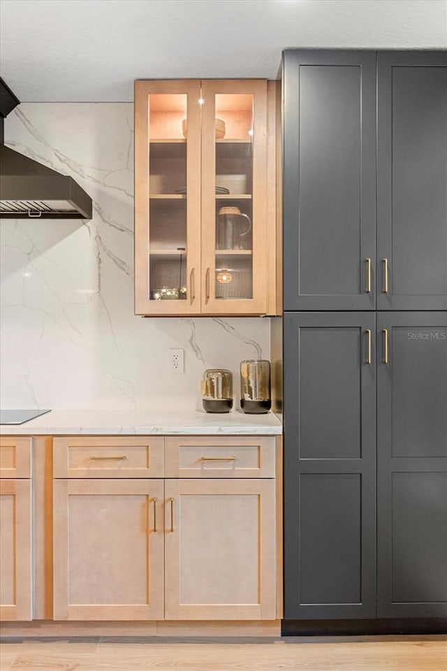 bar featuring black electric stovetop, light wood-style floors, and decorative backsplash