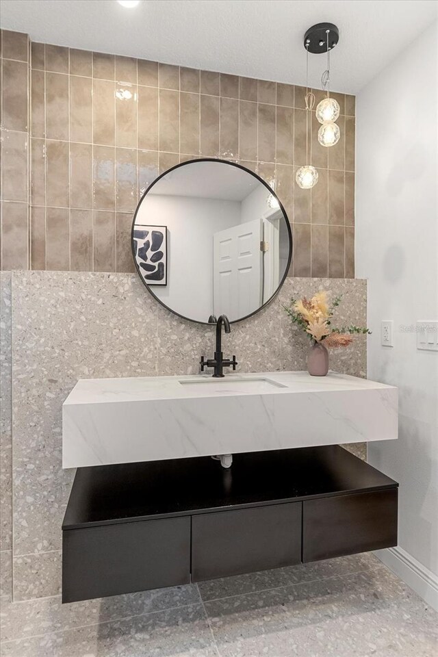 bathroom with tasteful backsplash, vanity, and baseboards