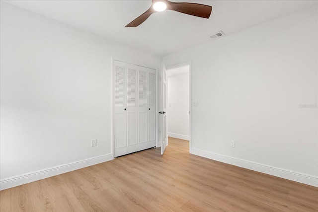 unfurnished bedroom featuring visible vents, baseboards, a ceiling fan, light wood-style flooring, and a closet