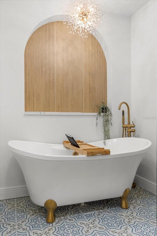 full bath featuring tile patterned flooring, baseboards, and a freestanding bath