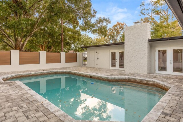 view of swimming pool featuring a fenced in pool, french doors, a patio area, and fence