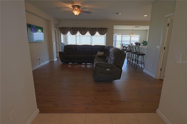 living room featuring ceiling fan, plenty of natural light, and dark hardwood / wood-style floors