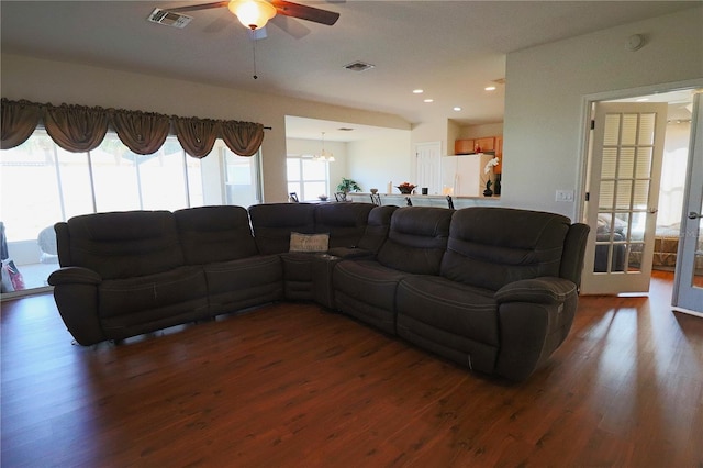 living room featuring dark wood-type flooring and ceiling fan with notable chandelier