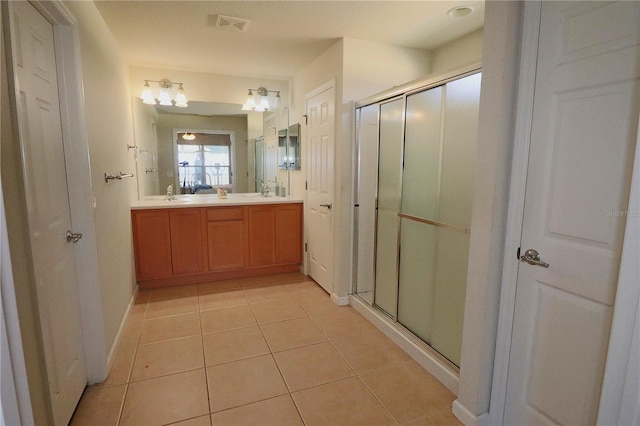 bathroom featuring tile patterned flooring, vanity, and an enclosed shower