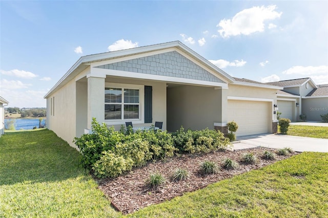 view of front of home with a garage, concrete driveway, a water view, a front lawn, and stucco siding