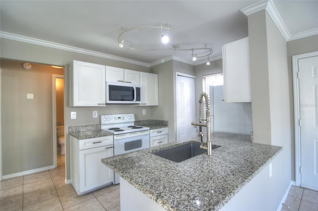 kitchen with white appliances, a sink, white cabinets, light tile patterned flooring, and a peninsula