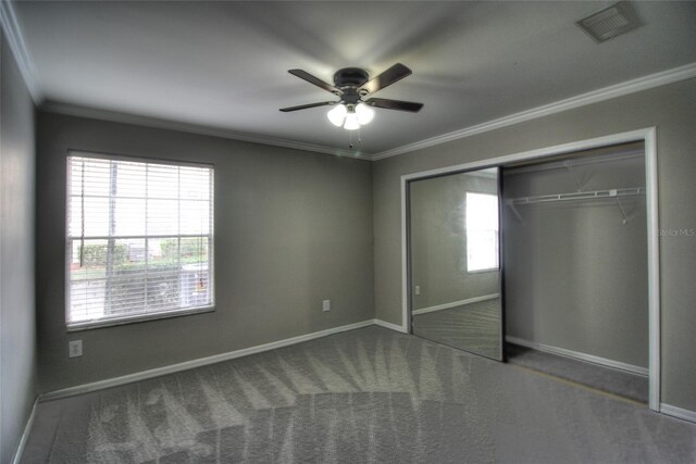 unfurnished bedroom with crown molding, a closet, baseboards, carpet, and ceiling fan